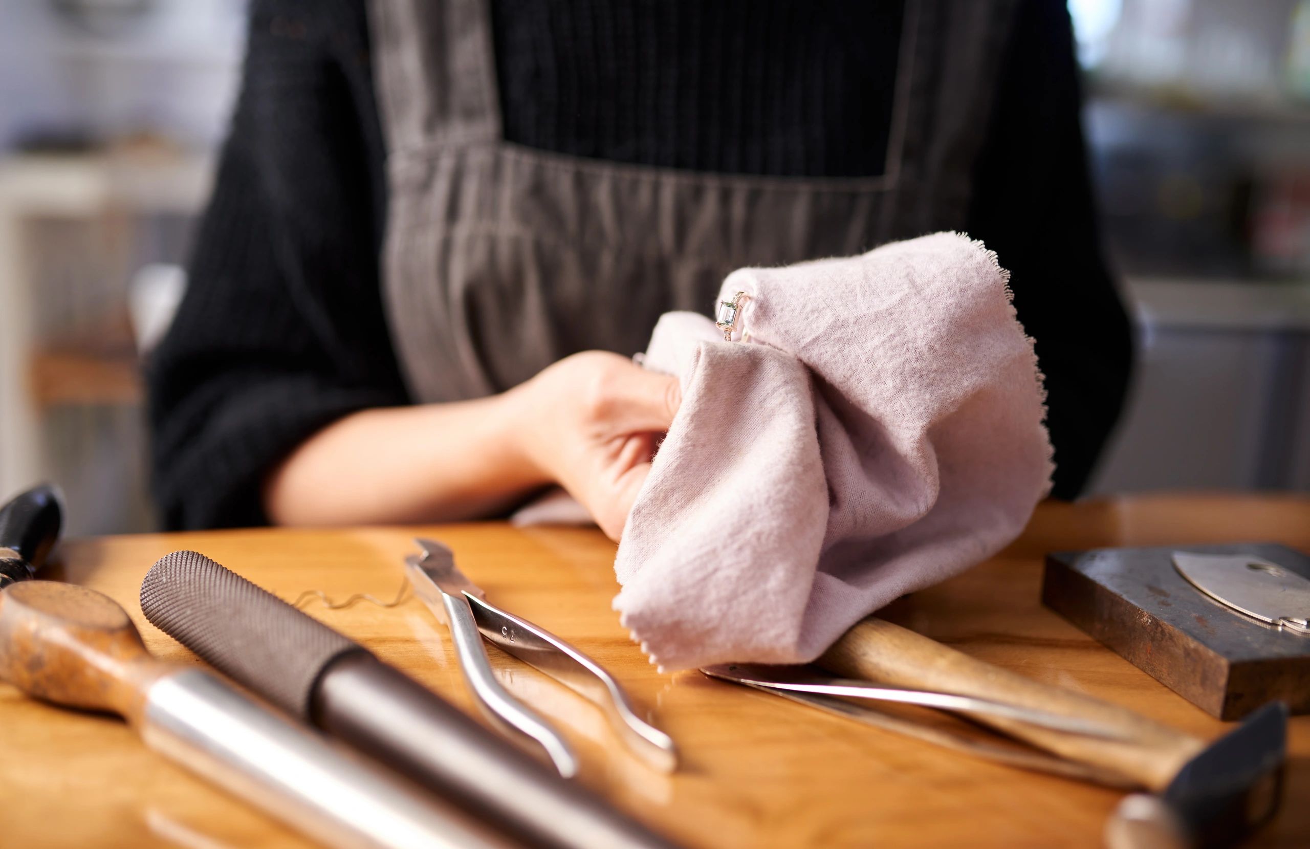 Jewellery being gently cleaned with tools on a workbench.