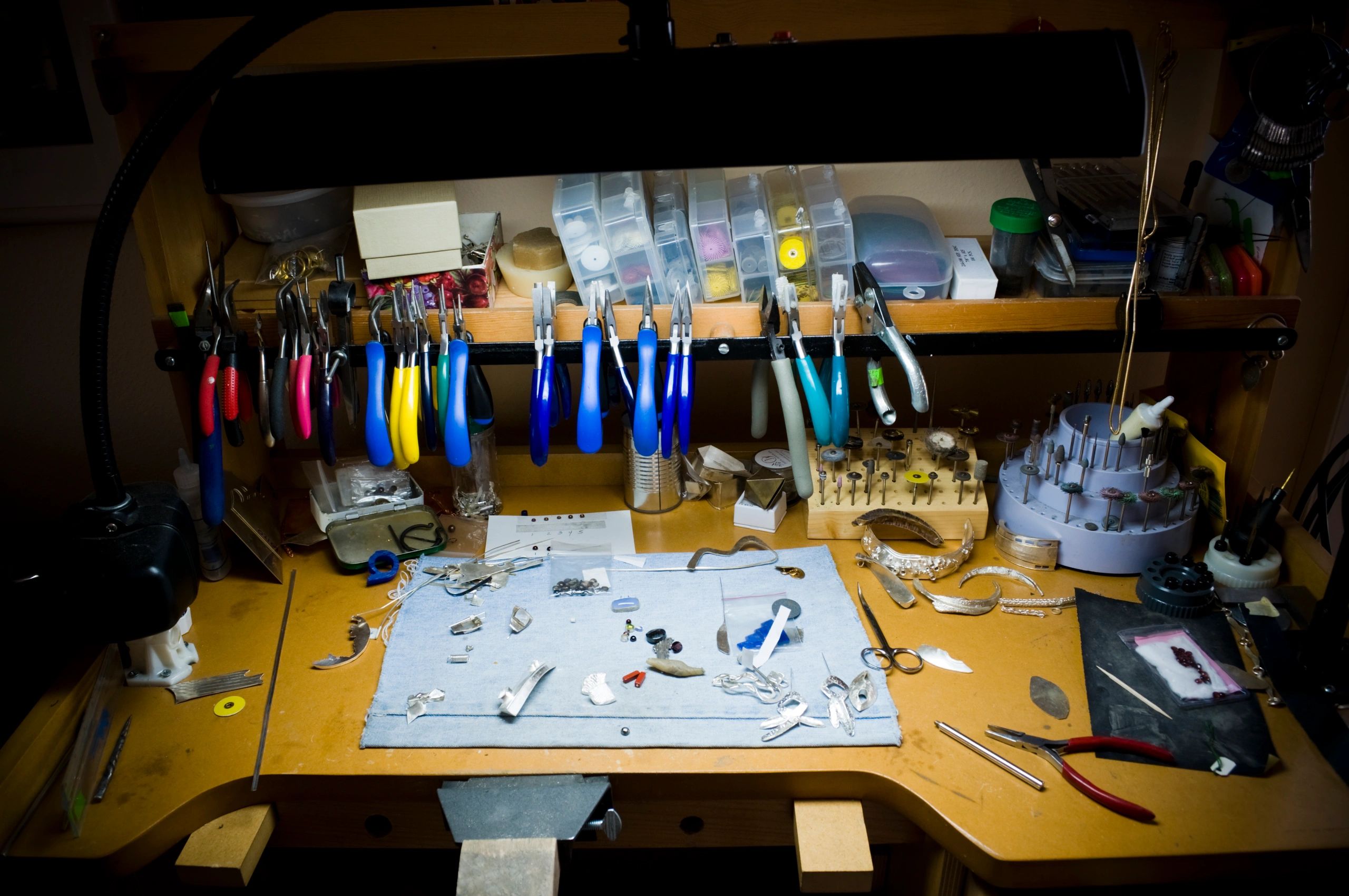 Jeweler’s workbench with tools and materials laid out.